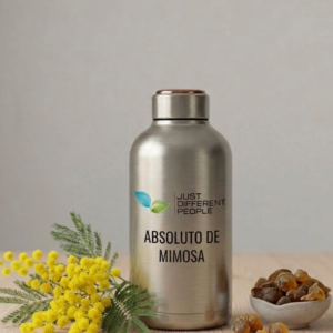 Stainless steel bottle with 'Absoluto de Mimosa' label and leaf logo, beside yellow mimosa flowers on a wooden surface.