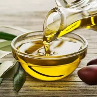 un-vaso-lleno-de-aceite-de-oliva-con-hojas-verdes-al-lado-y-una-botella-622f049529fdb